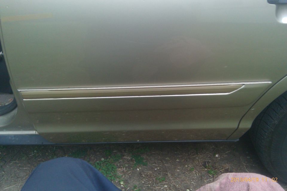 Gold car door trim with chrome accent, side view
