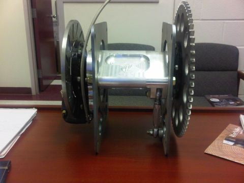 1996 Ford Bronco - A custom-machined spool assembly with a sprocket and brake disc is shown on a desk.