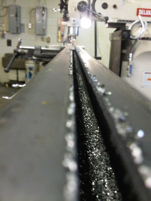 1996 Ford Bronco - Metal shavings accumulate on a beam during a machining process, with an industrial machine visible in the background.