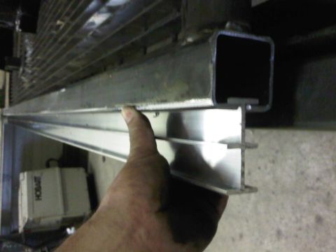 1996 Ford Bronco - A hand holds a metal extrusion near a grate, with a Hobart machine visible in the background.