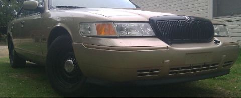 2000 Mercury Grand Marquis - A gold Mercury Grand Marquis is shown from the front quarter angle, a black grille.