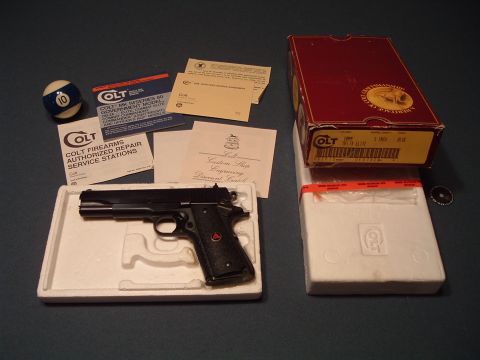 1995 Mercury Grand Marquis - A Colt pistol is displayed with its original packaging, manuals, and a billiard ball.