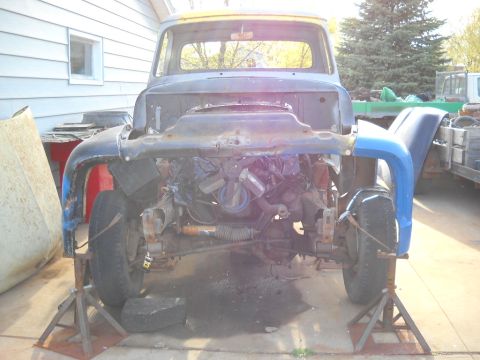 1954 Ford F-100 - A partially dismantled 1953 Ford F-100 truck is shown from the front, supported by jack stands.