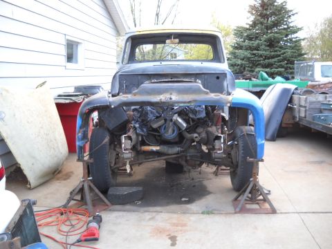 1954 Ford F-100 - Front view of a 1954 Ford F-100 truck undergoing restoration, with the engine visible.