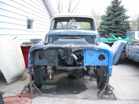 1954 Ford F-100 - This truck is in a state of disassembly, with its front end elevated on jack stands and the engine visible.