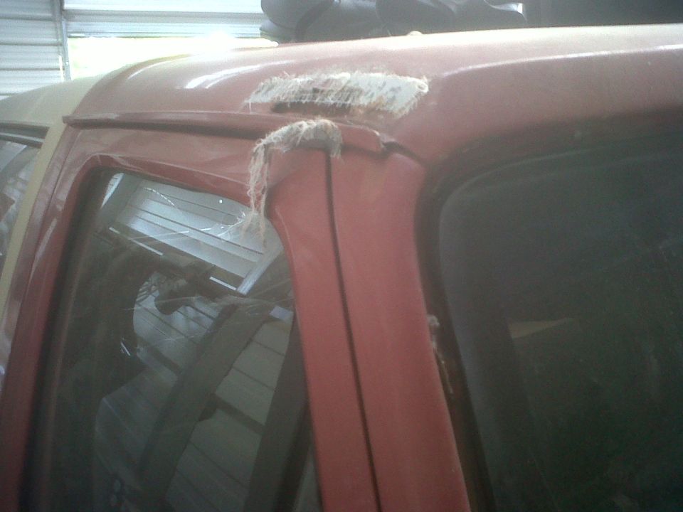 Red SUV door frame with fiberglass repair patch and exposed fibers