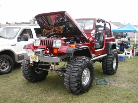 1994 Ford Bronco - Modified Jeep Wrangler on display with its hood raised, next to another vehicle.