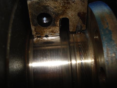 1979 Ford Bronco - Close-up view of a worn engine crankshaft bearing, showing signs of damage and lubrication.