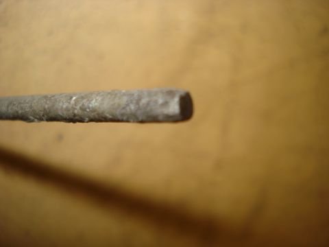 1979 Ford Bronco - A close-up view of a metal rod, possibly a component, against a blurred background.