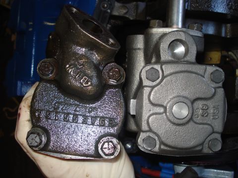 1979 Ford Bronco - An old, grimy oil pump is compared to a new one, showing visible part numbers on the older component.