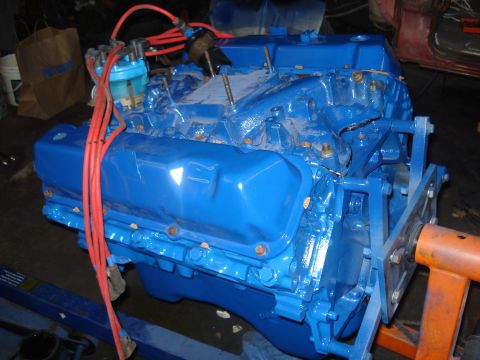 1979 Ford Bronco - A blue engine, likely a Ford 460, is mounted on an orange engine stand, ready for installation or work.