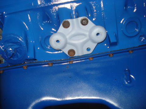 1979 Ford Bronco - A bracket is attached to a freshly painted blue engine block with several bolts.