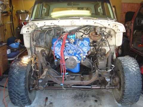 1979 Ford Bronco - Front view of a 1979 Ford Bronco's engine bay during restoration, showing the blue engine and suspension components.