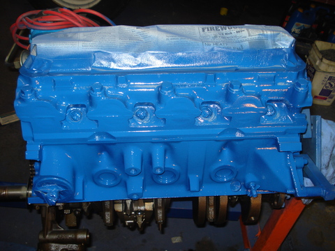1979 Ford Bronco - V8 engine block painted blue, with crankshaft exposed. Intake ports are covered with paper.