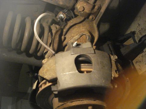 1979 Ford Bronco - This photo shows a close-up view of a vehicle's brake caliper and suspension system, with visible rust on the components.
