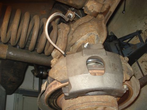 1979 Ford Bronco - Close-up view of a vehicle's brake caliper and suspension components, showing rust and wear.