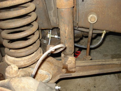 1979 Ford Bronco - Close-up view of the rear suspension components and brake lines, showing the shock absorber and coil spring.