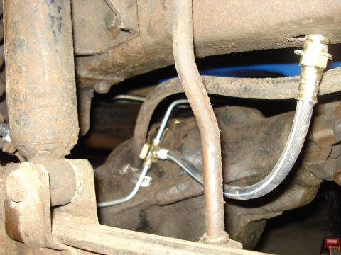 1979 Ford Bronco - Rear axle brake lines and shock absorber assembly, showing rusty metal components and brake lines.