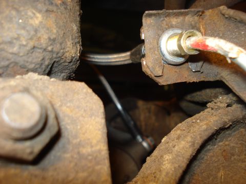 1979 Ford Bronco - Brake line connection detail on rusty bracket. SuperMotors.net logo is present.