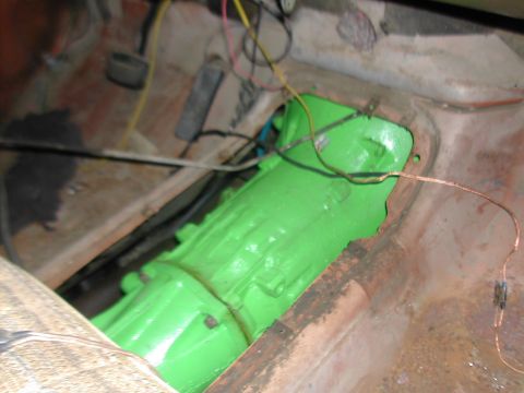 1979 Ford Bronco - Transmission housing painted bright green, with wiring and rusty interior floor visible.