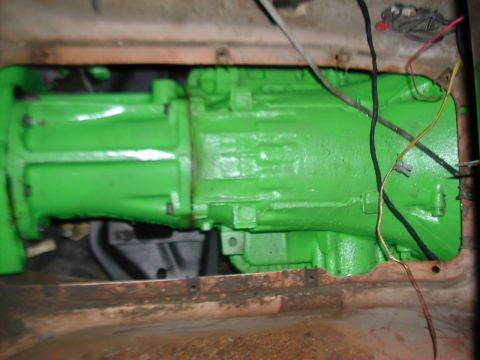 1979 Ford Bronco - This photo shows a transmission, painted bright green, with electrical wires connected to it.