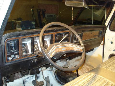 1979 Ford Bronco - The interior of a 1979 Ford Bronco shows its distinctive wood-grain dashboard and steering wheel.