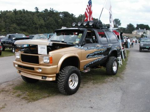 1994 Ford Bronco - This customized SUV is on display with its hood open, custom paint and off-road tires.