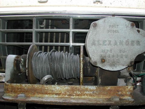 1979 Ford Bronco - A close-up view of a winch attached to the front of a vehicle, with visible rust and manufacturer details.