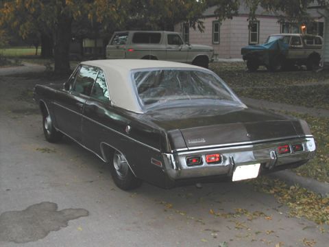 1971 Dodge Dart - Rear view of a 1971 Dodge Dart with a vinyl roof, parked outdoors with other vehicles behind it.