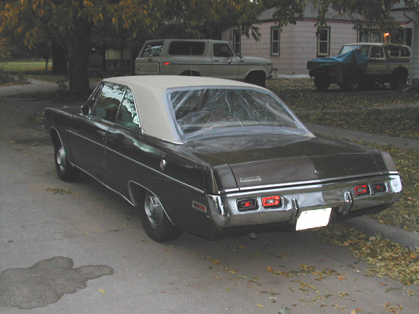 1971 Dodge Dart parked on street, two SUVs in background