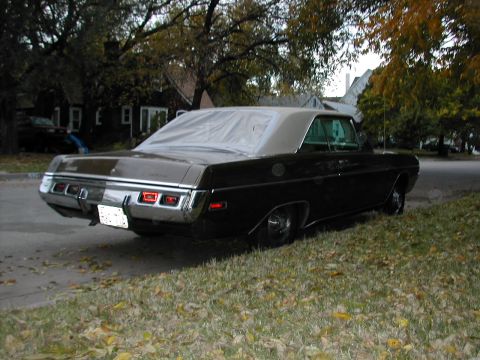 1971 Dodge Dart - Rear view of a dark-colored Dodge Dart with a vinyl roof, parked on a street in autumn.