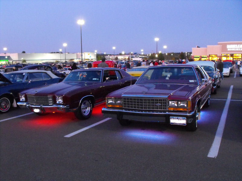 Maroon 1985 Ford Crown Victoria LTD with blue underglow, parked in a lot at dusk