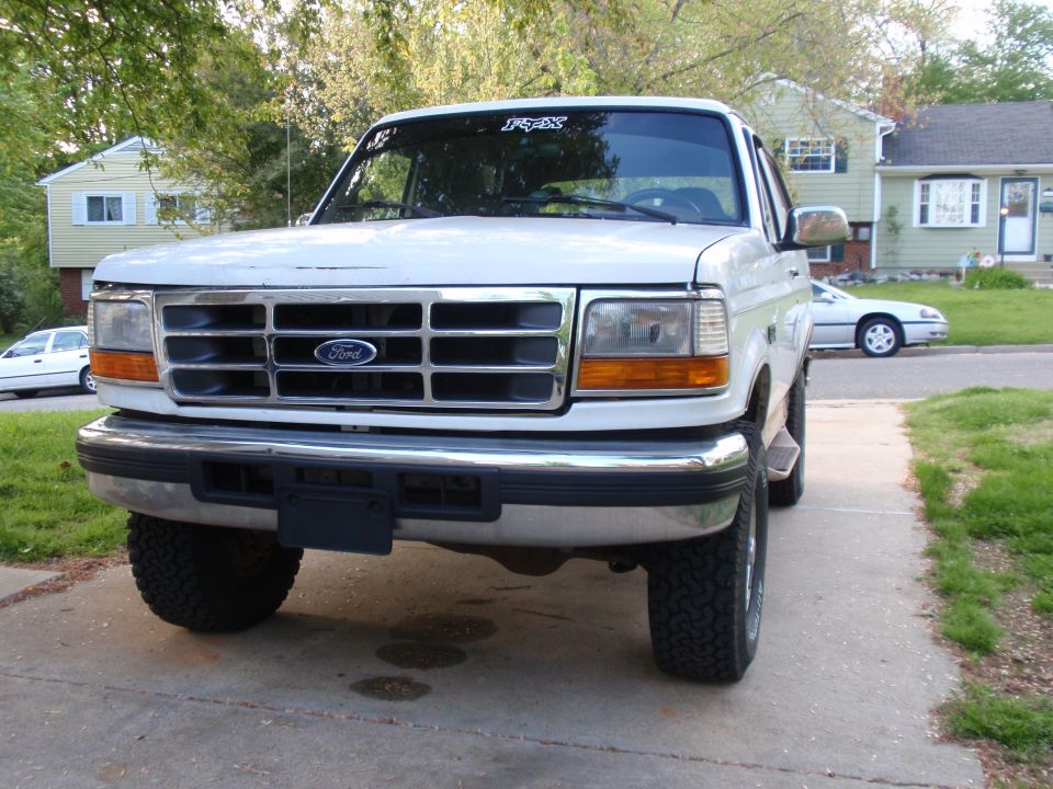 White Ford F-Series truck parked in driveway, another car in background