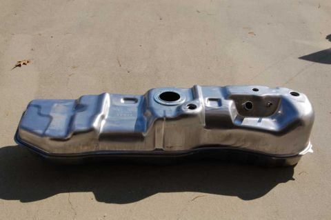 2007 Ford Mustang - A metal fuel tank is shown resting on a concrete surface outdoors.