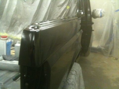 1993 Ford Bronco - A car door is being worked on in a workshop, covered in plastic sheeting.