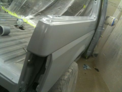 1993 Ford Bronco - This vehicle body panel is undergoing preparation in a paint booth, with protective coverings in place.