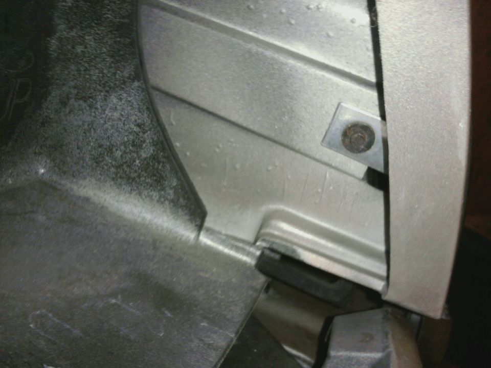 Close-up of a silver-colored vehicle part with a bolt and bracket