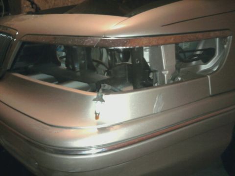 1996 Mercury Grand Marquis - Close-up of a tan car's front end, showing chrome bumper trim and a woodgrain accent strip.