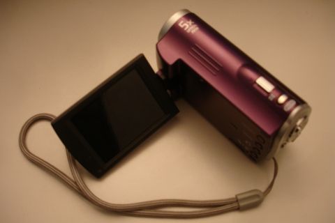 1993 Ford Taurus - A purple camcorder is shown with its screen open, resting on a neutral background.