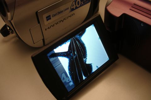 1993 Ford Taurus - A close-up shows a camcorder with a severely cracked LCD screen, with another camcorder visible behind it.