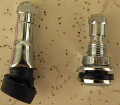 1995 Ford Bronco - Two tire valve stems are shown against a speckled background, with one stem appearing longer than the other.