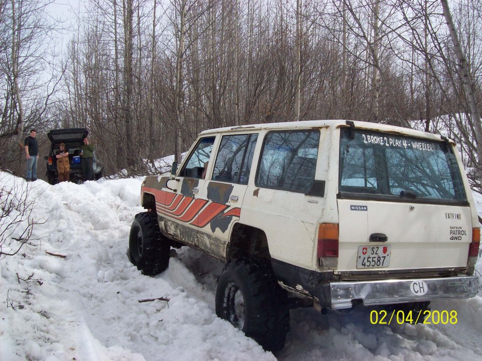 Nissan Patrol 4x4 with custom graphics in snow, another vehicle in background