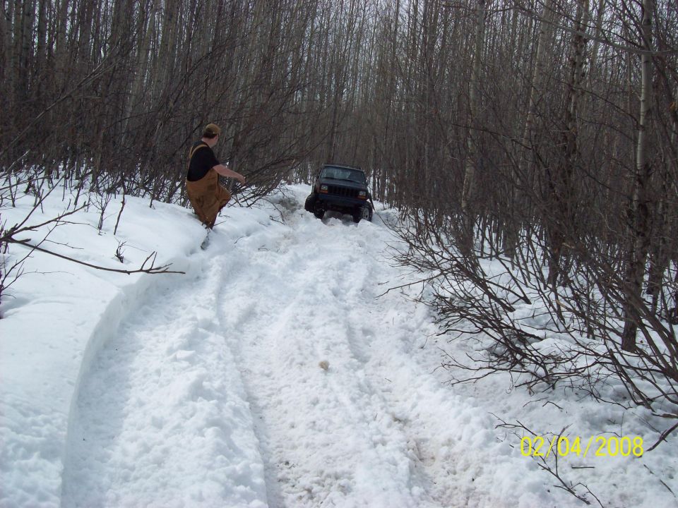 Dark SUV driving up a snowy hill, 2008 Supermotors watermark