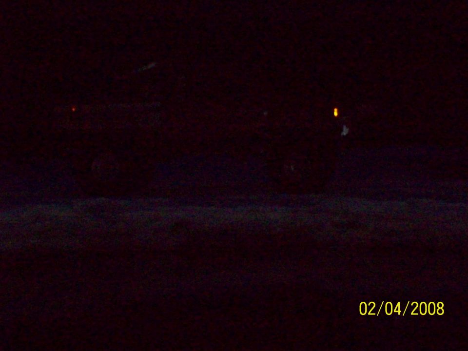 dark vehicle with faint lights visible at night, timestamp 02/04/2008