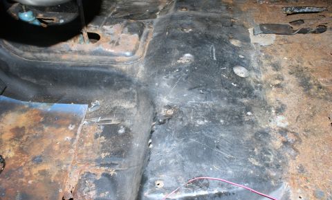1979 Ford Bronco - Interior floor pan shows significant rust damage and wear.