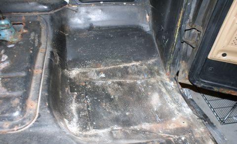 1979 Ford Bronco - Vehicle interior floor showing rust and wear after removal of seats and carpets.