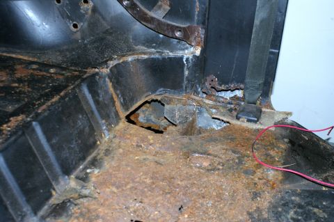 1979 Ford Bronco - Interior floor pan shows significant rust damage, indicating a need for restoration.
