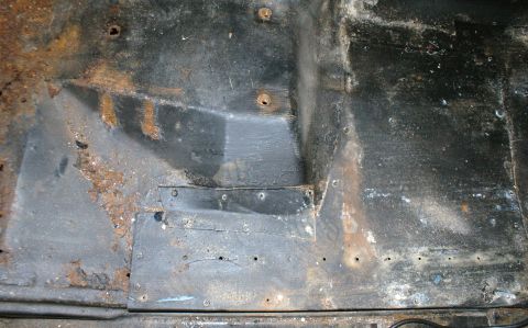 1979 Ford Bronco - Interior floor pan shows extensive rust damage and repairs.