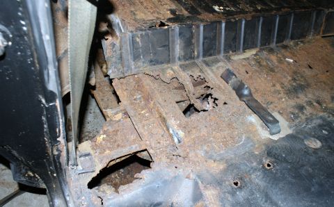 1979 Ford Bronco - Extensive rust damage is visible on the floor pan of this vehicle, indicating significant deterioration.