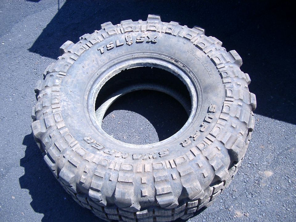 Unmounted Interco Super Swamper TSL SX mud tire lying on pavement